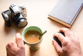 Closeup shot of a cup of tee and a camera on a wooden table Royalty Free Stock Photo