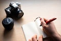 Closeup shot of a cup of tee and a camera on a wooden table Royalty Free Stock Photo