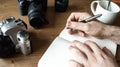 Closeup shot of a cup of tee and a notebook camera on a wooden table Royalty Free Stock Photo