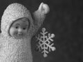 Closeup shot of a cute baby angel statuette holding a snowflake Royalty Free Stock Photo