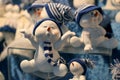 Closeup shot of cute snowman figures wearing Santa hat and scarf in the Christmas market