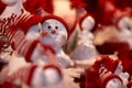 Closeup shot of cute snowman figures wearing Santa hat and scarf in Christmas market