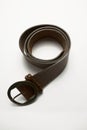 Closeup shot of dark brown leather belt on a white background Royalty Free Stock Photo