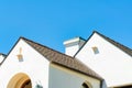 Closeup shot of dark open gable roofs of white buildings and a chimney under the blue sky