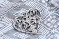 Closeup shot of a decorated metallic heart on a patterned white tablecloth