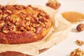 Closeup shot of a delicious apple walnut cake with honey surrounded by ingredients on a white table Royalty Free Stock Photo