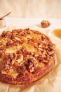 Closeup shot of a delicious apple walnut cake with honey surrounded by ingredients on a white table Royalty Free Stock Photo