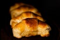 Closeup shot of delicious croissants in a row under the light with a blurry background Royalty Free Stock Photo