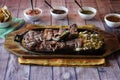 Closeup shot of delicious parrillada, different kind of meats on one plate on a wooden surface Royalty Free Stock Photo