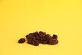 Closeup shot of the delicious raisins on the yellow background