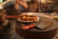 Closeup shot of delicious satay in a white plate with a knife on a wooden chopping board