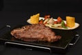 Closeup shot of delicious steak with vegetable sidedish isolated on a black background