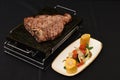 Closeup shot of delicious steak with vegetable sidedish isolated on a black background