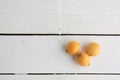 Closeup shot of delicious yellow medlar fruits on a white wooden surface Royalty Free Stock Photo