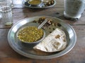 Closeup shot of a dish small portion with bread in a metal plat in India