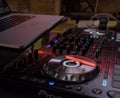 Closeup shot of a DJ mixer with a laptop on top