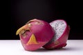 Closeup shot of a dragon fruit cut in a half on a white surface with a black background Royalty Free Stock Photo