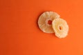 Closeup shot of the dried pineapple slices isolated on an orange background Royalty Free Stock Photo