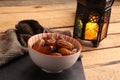 Closeup shot of  dry dates fruit in a bowl and lantern with a yellow light on the side Royalty Free Stock Photo
