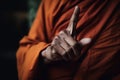 Closeup shot of an elderly Buddhist monk's hand with raised pointing finger. AI-generated.