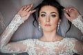 Closeup shot of an elegant, brunette bride in vintage white dress posing under veil closeup Royalty Free Stock Photo