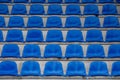 Closeup shot of empty blue grandstand chairs at the football stadium