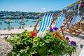 Closeup shot of empty deck chairs and flower pots overlooking the harbor on a sunny day