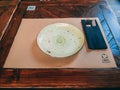 Closeup shot of an empty plate on wooden table in restaurant