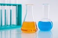 Closeup shot of an Erlenmeyer flask with orange liquid and a round flask with blue liquid at a lab Royalty Free Stock Photo