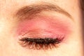 Closeup shot of eye makeup with pink shadow and heavy mascara