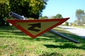 Closeup shot of a fallen triangular road sign on the green grass on the side of the road