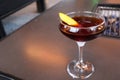 Closeup shot of fancy bourbon cocktail with a citrus garnish on a fire table in Austin, Texas