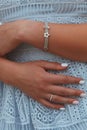 Closeup shot of a female in a blue dress wearing a beautiful silver bracelet and a ring Royalty Free Stock Photo