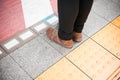 Closeup shot of female feet standing on a textured colorful sidewalk