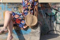 Closeup shot of a female in a floral dress holding a knitted purse