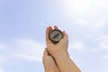 Closeup shot of a female hand holding an old compass under the blue sky Royalty Free Stock Photo