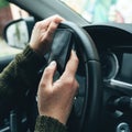 Closeup shot of female hand typing message on smartphone device, casual woman driver wearing green knitted sweater using mobile