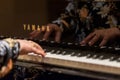 Closeup shot of female hands playing the keys on a Yamaha piano