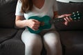 Closeup shot of a female playing a green ukulele