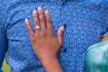 Closeup shot of a female's hand with an engagement ring on her fiance's chest