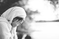 Closeup shot of a female wearing a biblical robe and crying in black and white Royalty Free Stock Photo