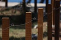 Closeup shot of a fence made of wooden poles and metal cables Royalty Free Stock Photo