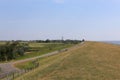 Closeup shot of a field with a road with a lighthouse in the background