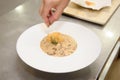 Closeup shot of finalization of the Italian risotto dish with parmesan