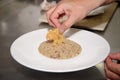 Closeup shot of finalization of the Italian risotto dish with parmesan