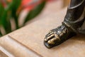 Closeup shot of a foot of a statue with orange blur background