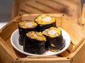 Closeup shot of four pieces of homemade sushi in the wooden box