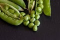 Closeup shot of fresh green pea seeds on black wooden background Royalty Free Stock Photo