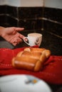 Closeup shot of fresh homemade bread rolls and a hand reaching for a cup of coffee Royalty Free Stock Photo