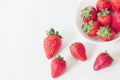 Closeup shot of fresh juicy strawberries near a bowl